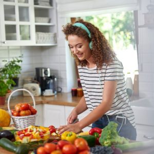 mom preparing food and listening to food allergy podcast