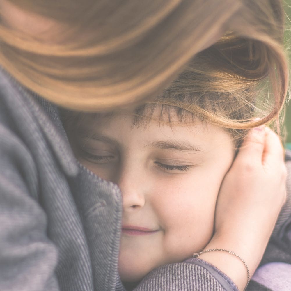 This image depicts a mom hugging her son, representing her love for him and their preparation for their food allergy appointment after an allergic reaction.